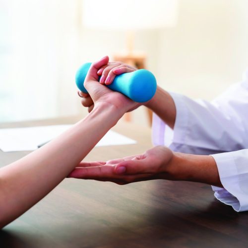 The doctor performed hand physical therapy for the patient with dumbbells.